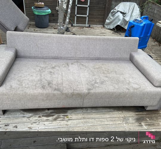 ספה אפורה עם כתמים על משטח עץ
